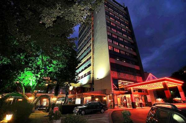 A multi-story hotel with a modern design, featuring a prominent entrance with a red-lit canopy. - Leipzig Hotel (Plovdiv)