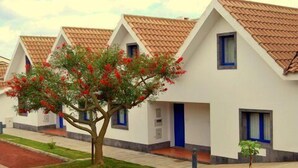 A row of white buildings with brown tiled roofs and blue-framed windows. - Apartamentos Turísticos Nossa Senhora da Estrela (Lagoa)
