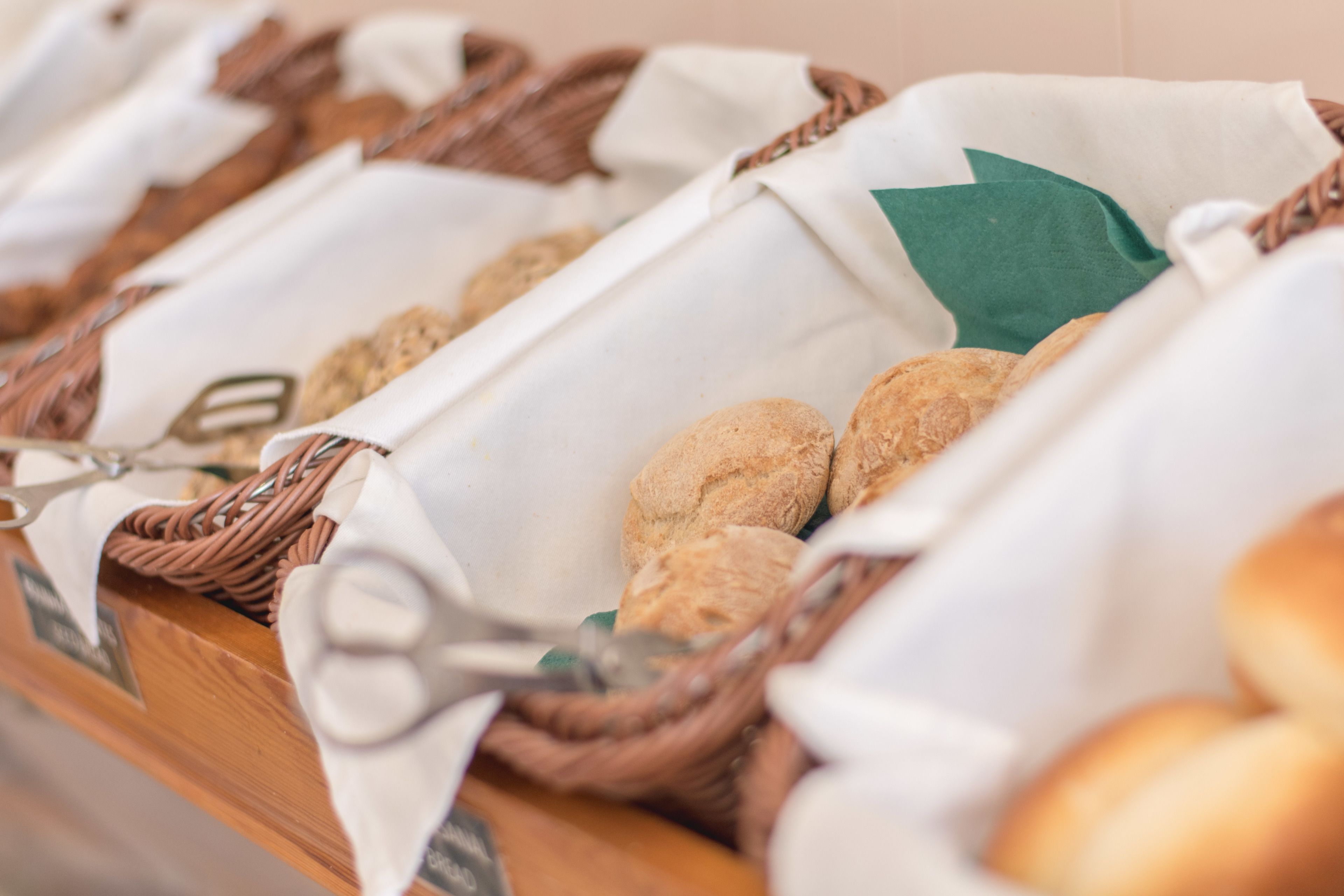 Un buffet con cesti pieni di prodotti da forno assortiti.