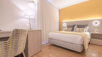 Une chambre d’hôtel moderne équipée d’un lit, de tables de chevet, d’un bureau et d’une chaise.