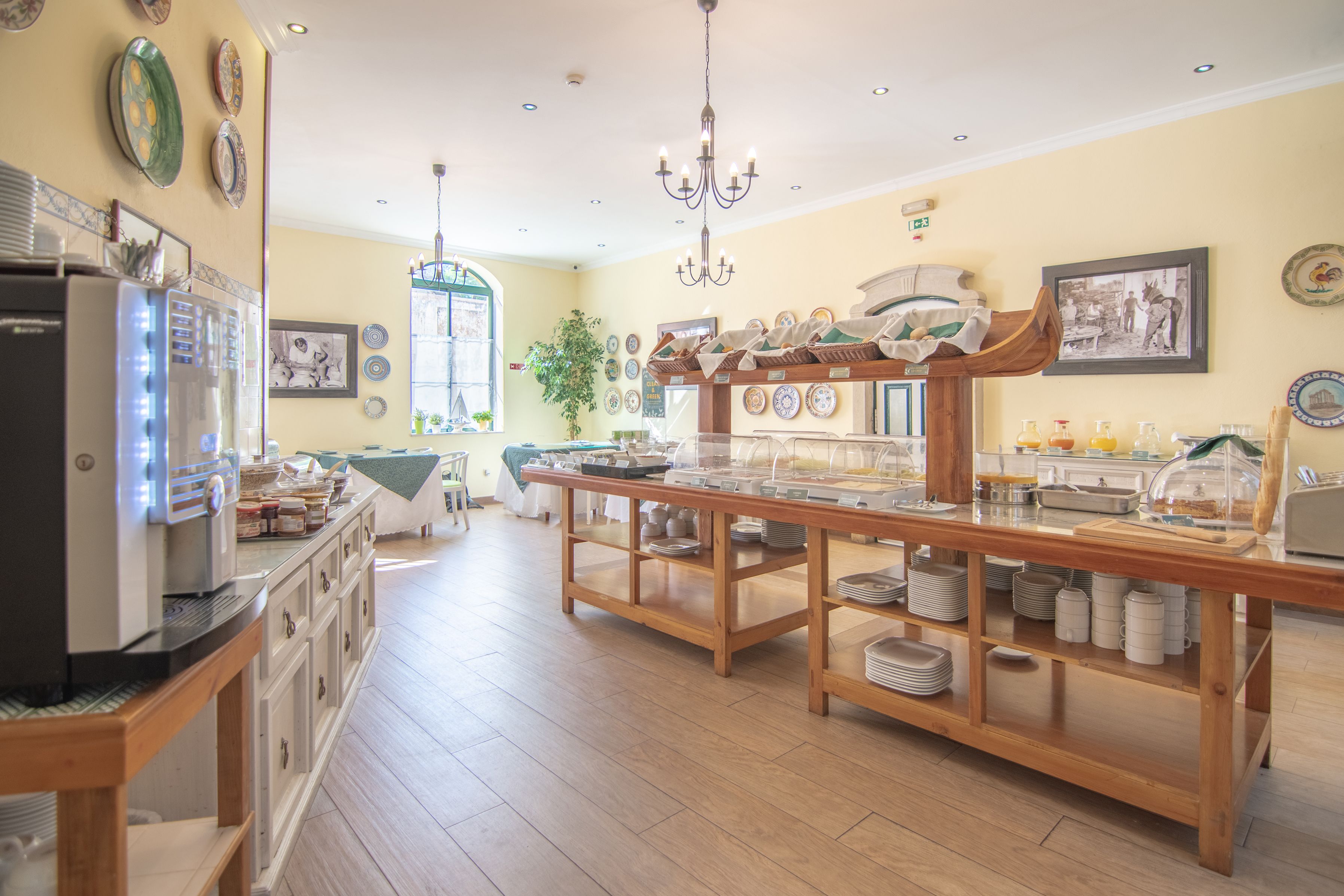A breakfast buffet with a variety of dishes, a refrigerator, and a chandelier.