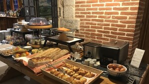 Un buffet de petit-déjeuner proposant un assortiment de viennoiseries, de pains et un coin café.