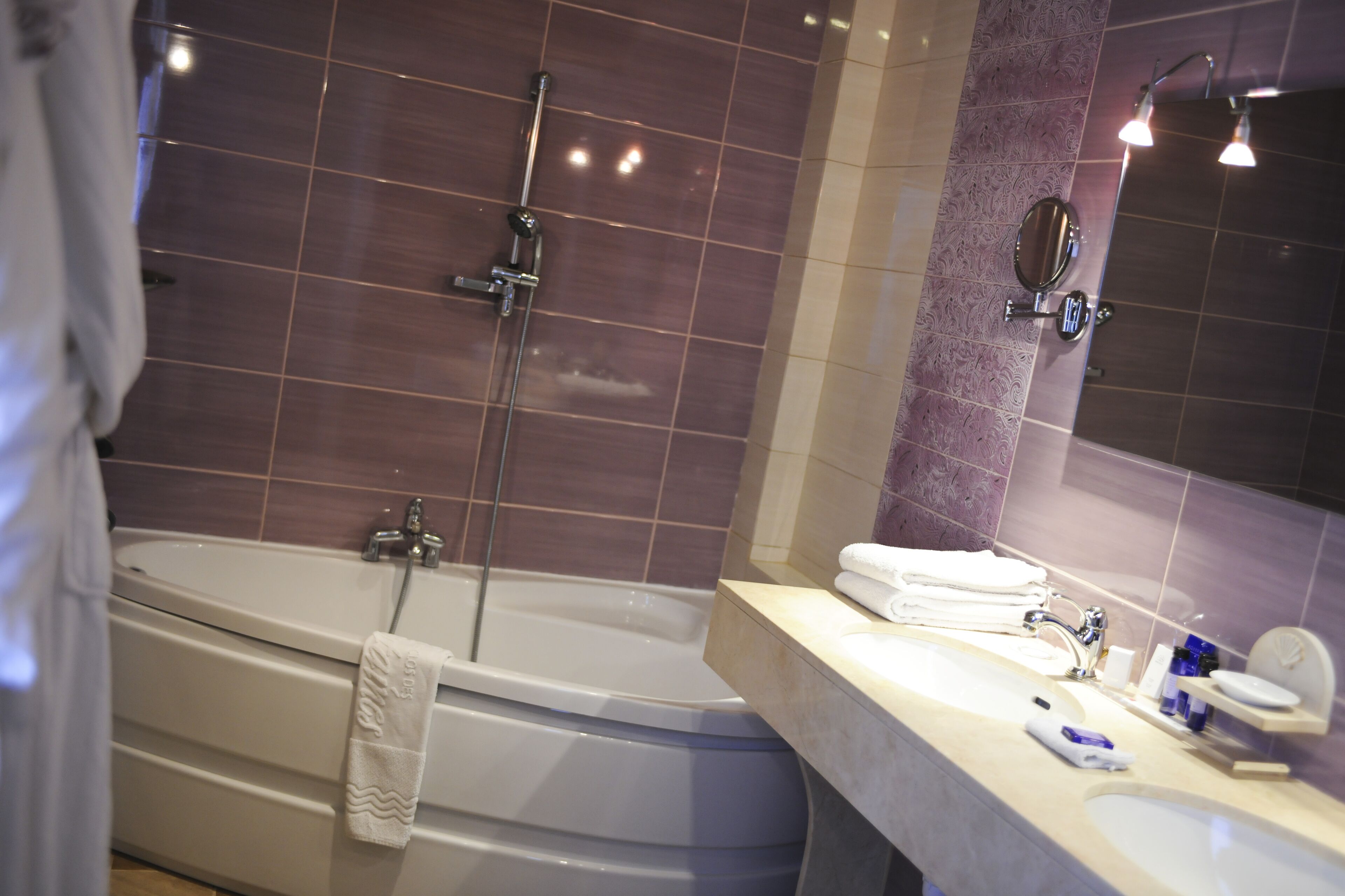 Ein Badezimmer mit Badewanne, Dusche, Waschbecken und Spiegel.
