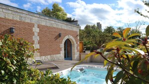Un bâtiment en briques doté d’une terrasse en bois et d’un jacuzzi.