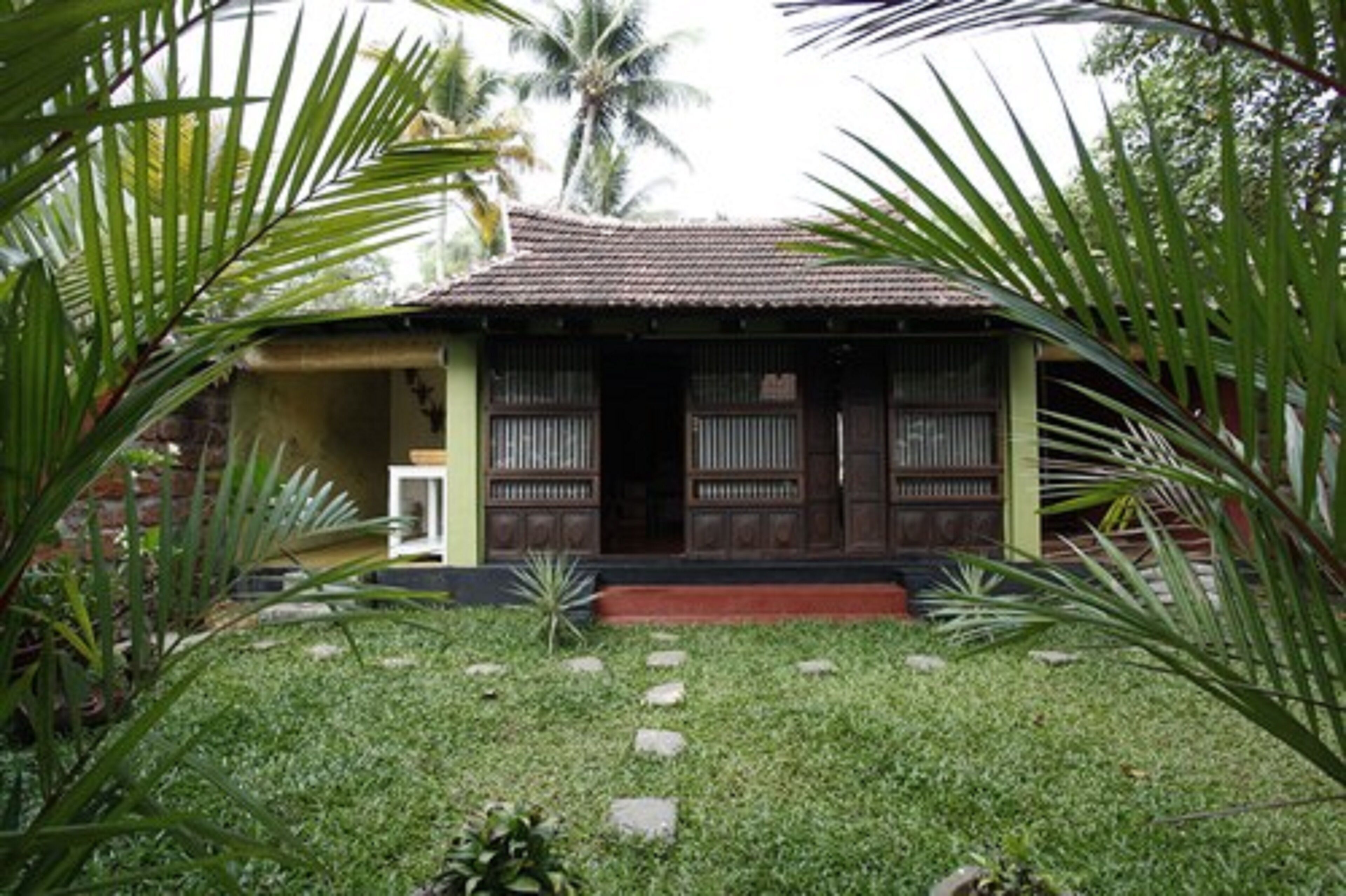 A traditional house with a tiled roof, wooden doors, and a small front porch.
