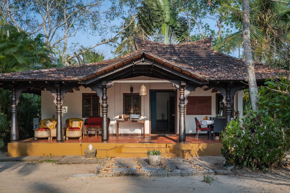 Ein traditionelles Haus mit Veranda, Essbereich und kleinem Garten.