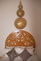 A bed with a wooden headboard, two decorative wall spheres, and patterned pillows.