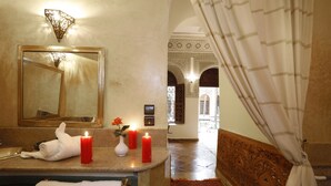 A bathroom with a mirror, a towel, and three red candles on the counter. - Riad Daria Suites & Spa (Marrakech)