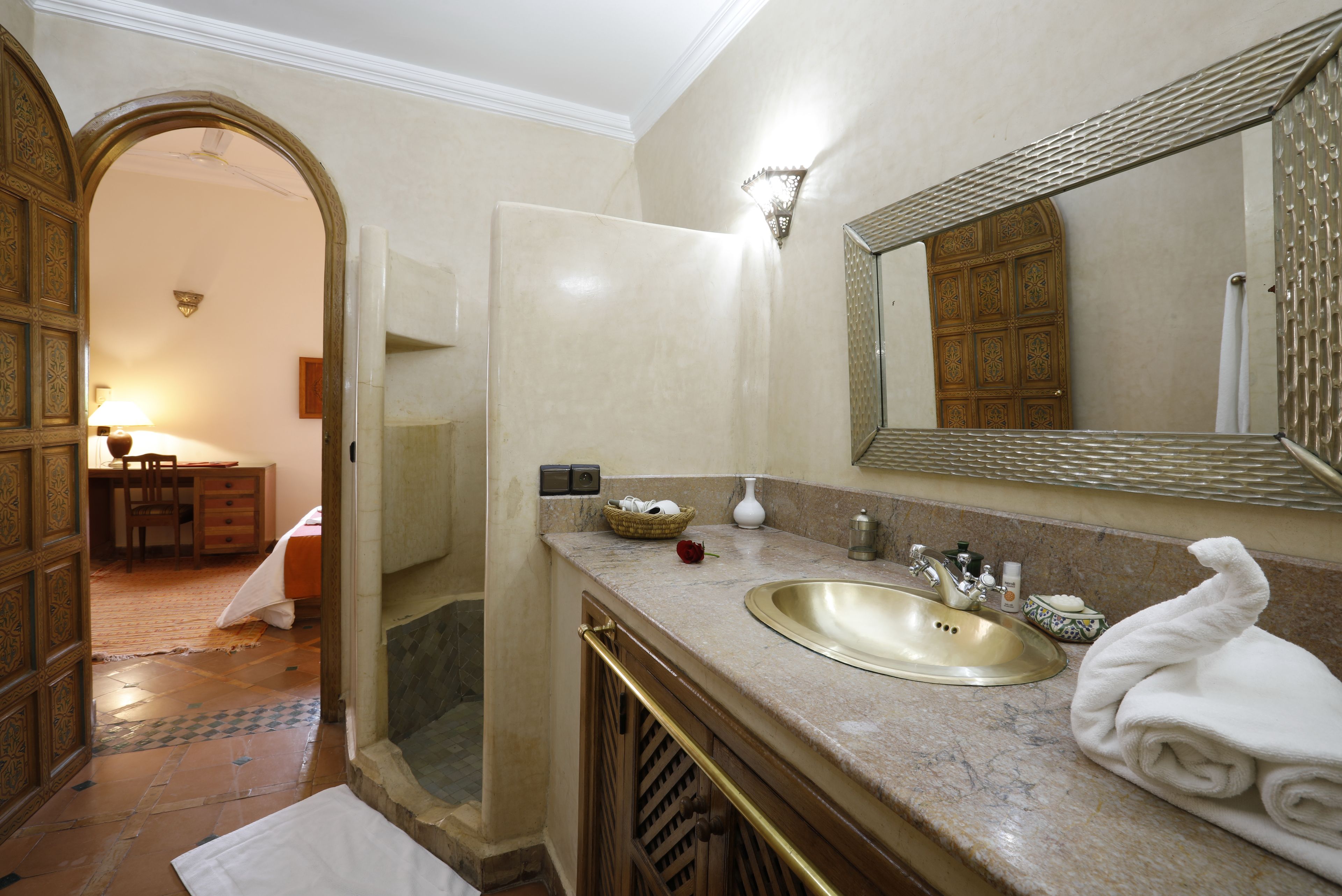 Un baño con lavamanos, espejo y toalla.