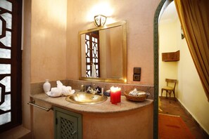 A bathroom with a sink, mirror, and a candle.