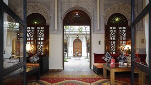 An interior with ornate arches, a patterned carpet, and a seating area with cushions and a table. - Riad Daria Suites & Spa (Marrakech)