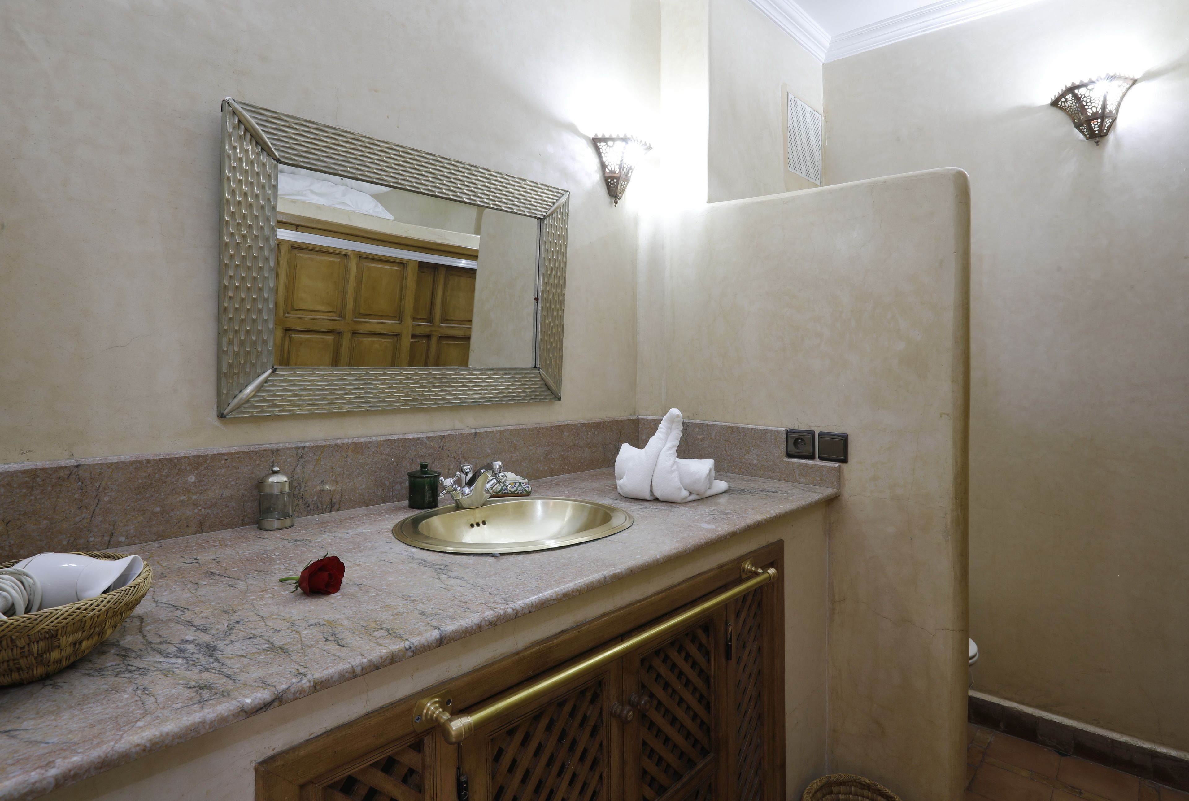 Une salle de bain avec un comptoir en marbre, un lavabo, un miroir et un porte-serviettes.