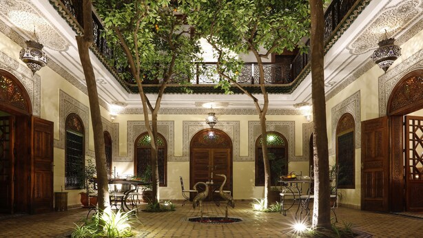 A courtyard with ornate arches, a fountain, and a dining area with tables and chairs. - Riad Daria Suites & Spa (Marrakech)