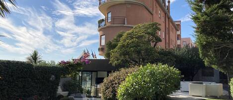 A building with a curved facade, balconies, and a sign reading "santamaria".
