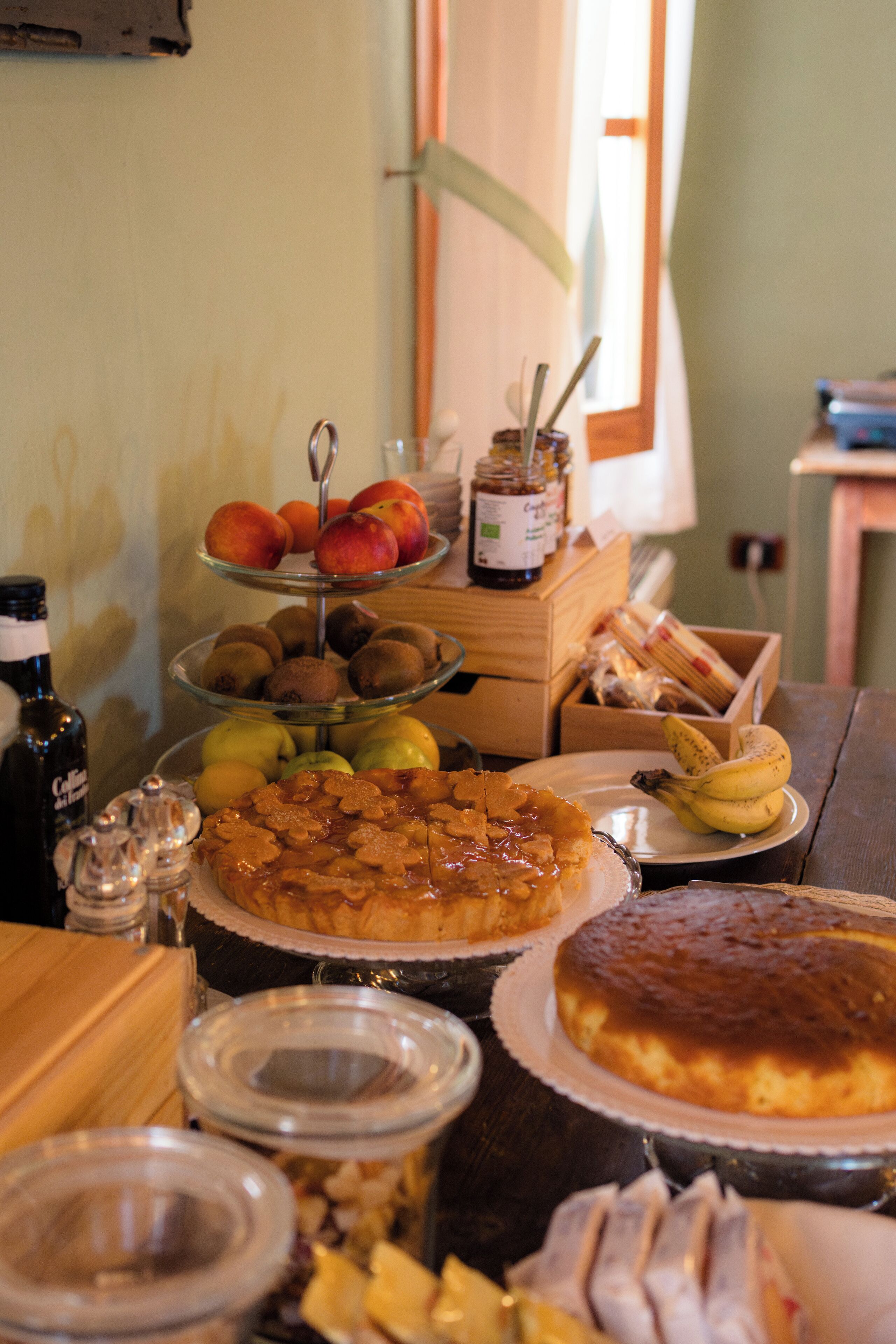 A table with various food items including fruits, pastries, and condiments.