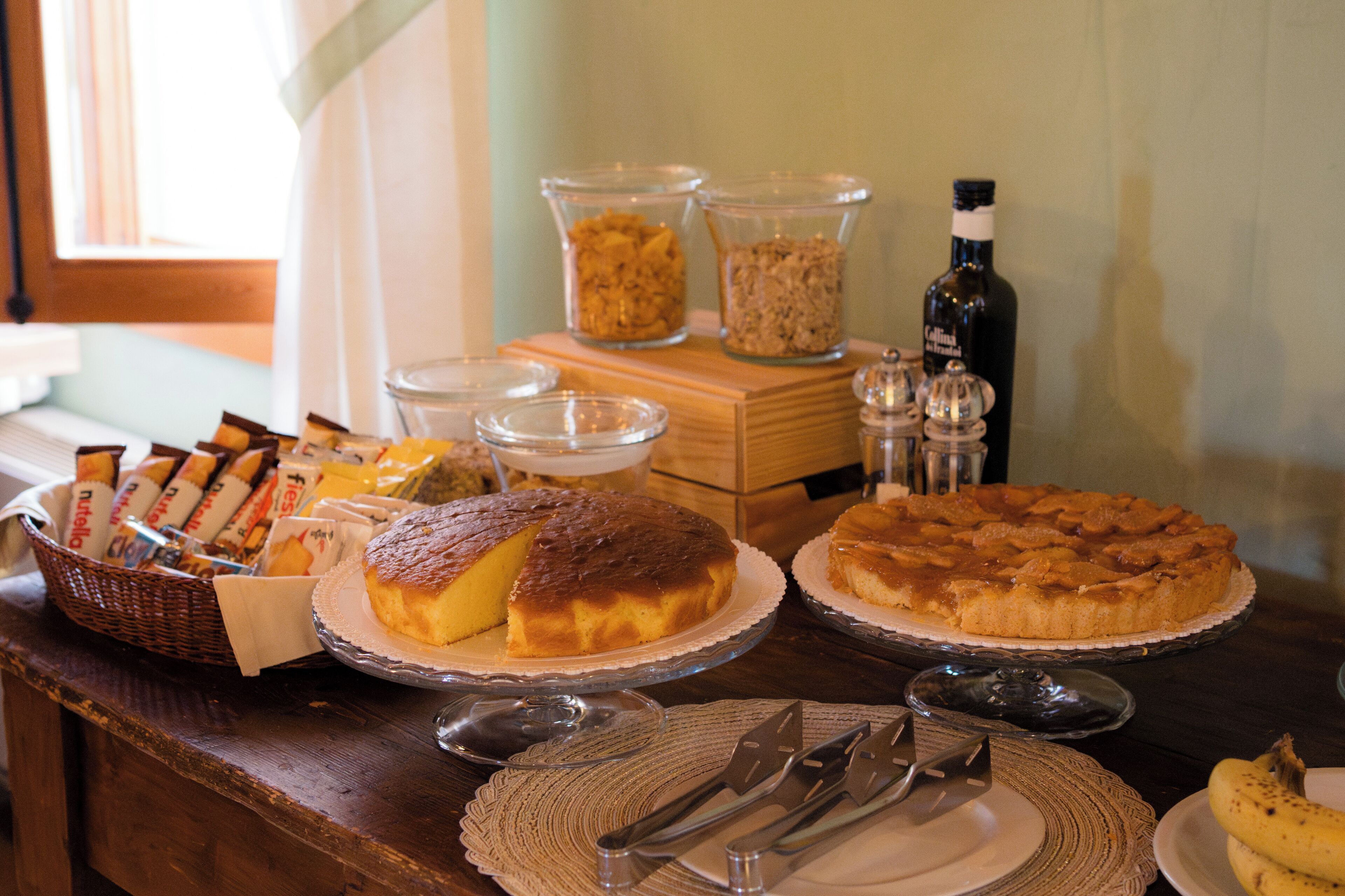 A breakfast buffet with various food items, including pastries and bread, on a wooden table.