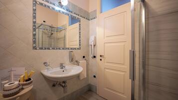 Une salle de bain avec un lavabo, un miroir et une douche.