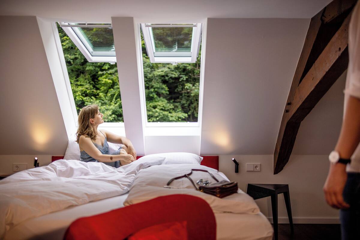 Une chambre à coucher avec une lucarne, un lit et une table de chevet.