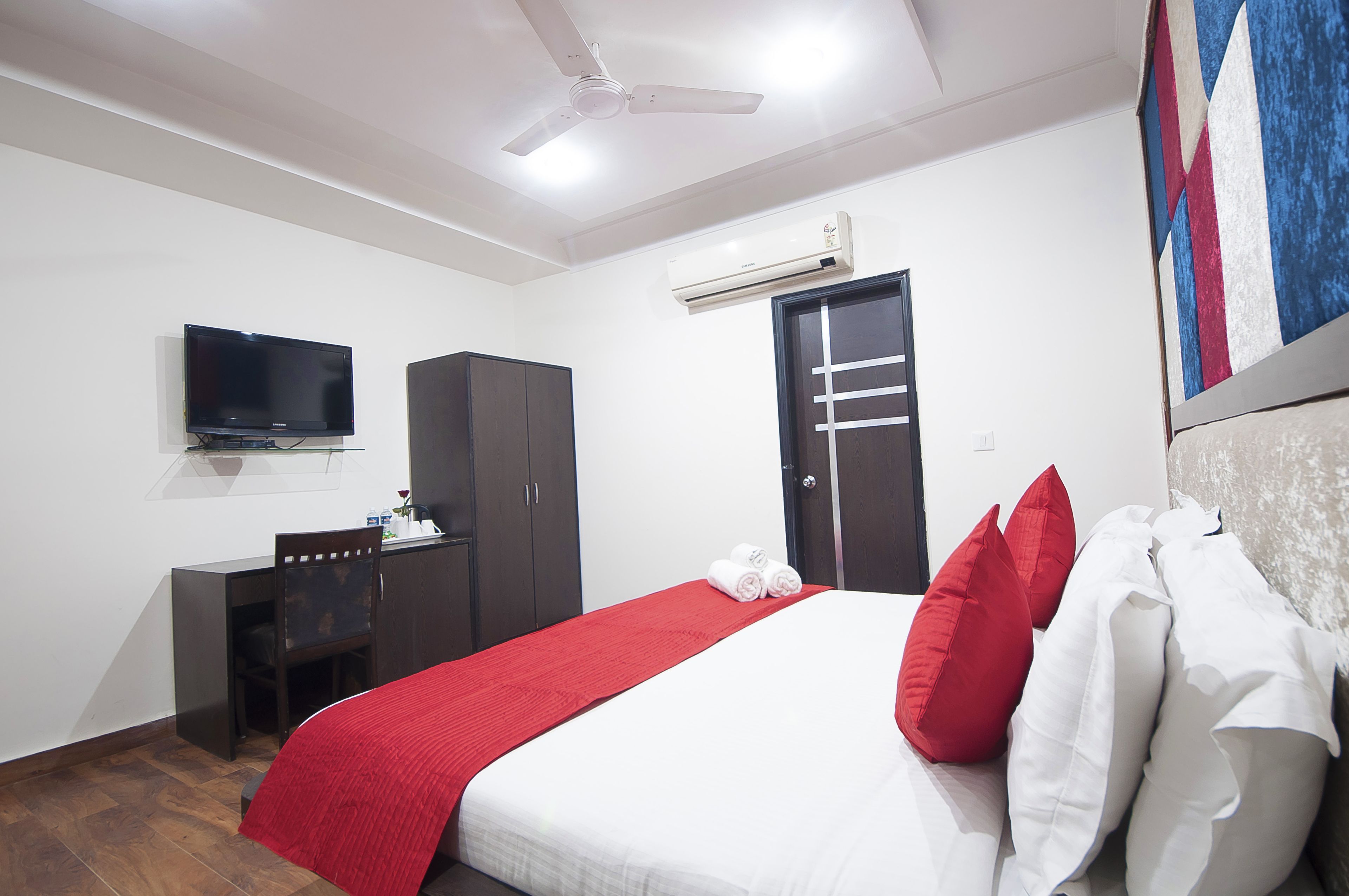 Une chambre d’hôtel équipée d’un lit, d’un bureau, d’une télévision et d’un appareil de climatisation.