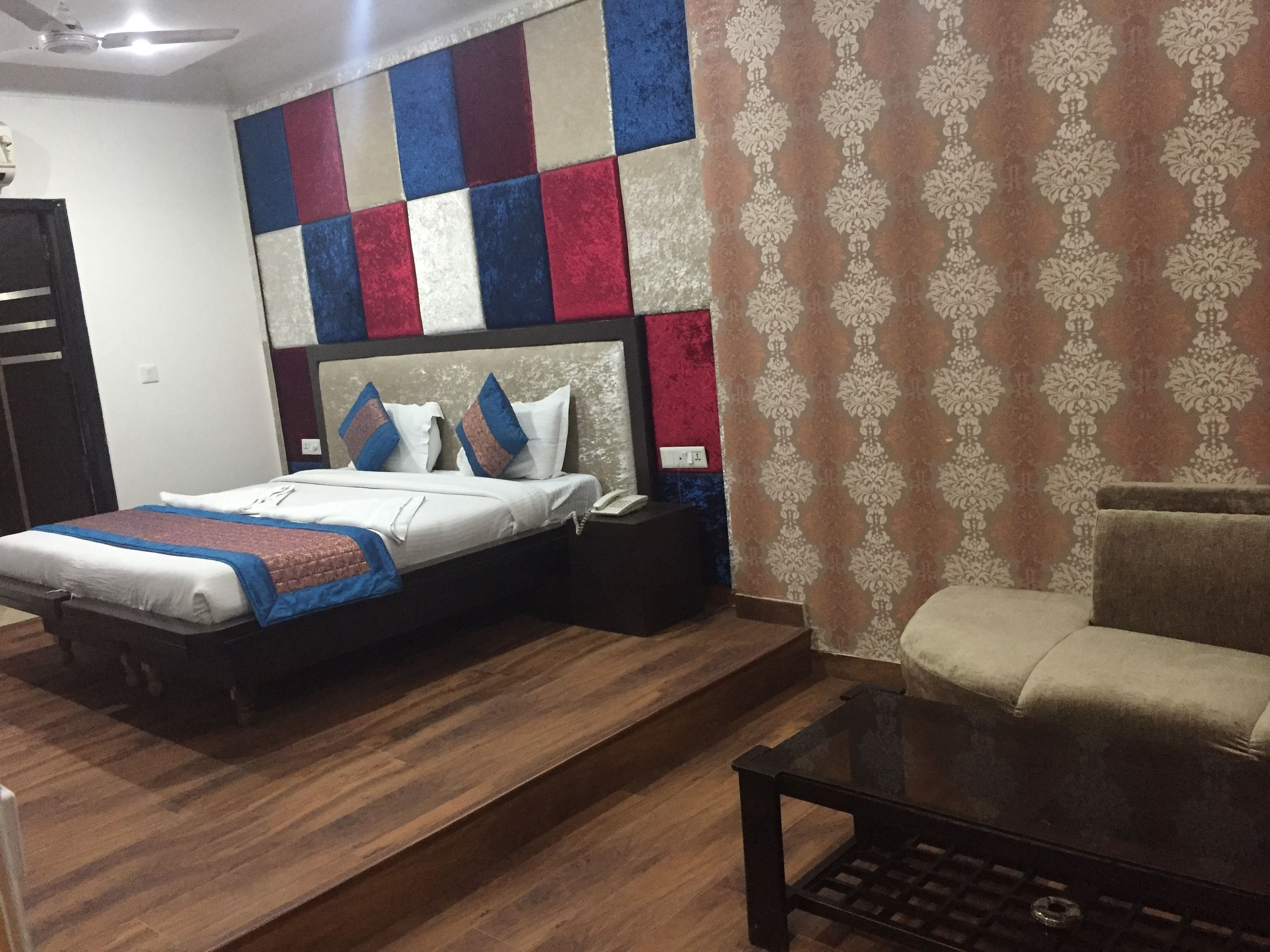 Une chambre d’hôtel avec un lit, une table de chevet et un petit canapé.