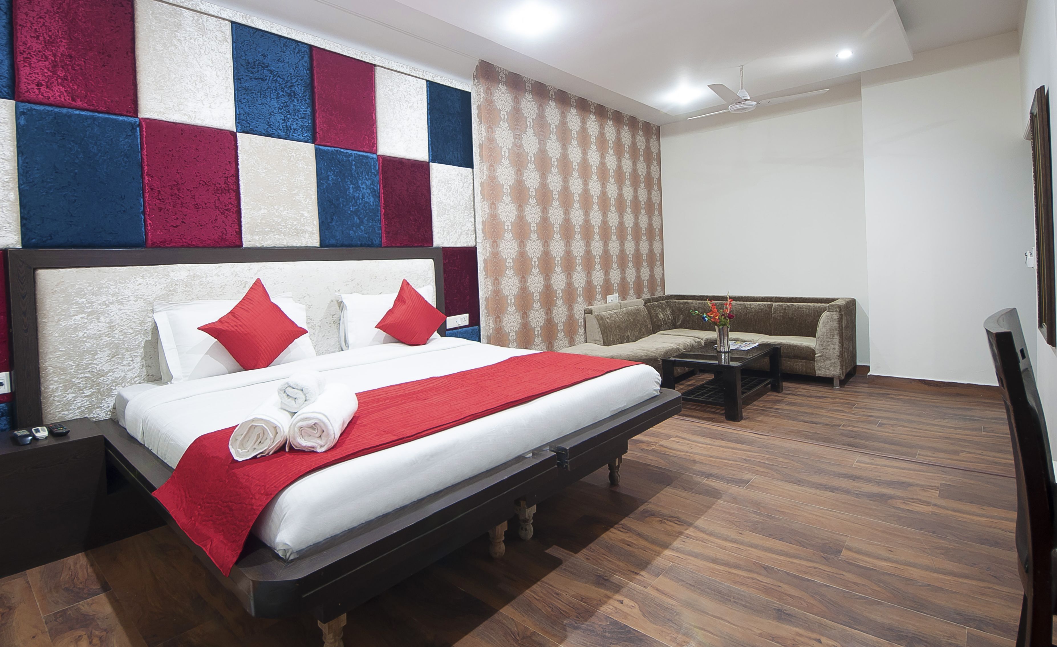 Una habitación de hotel con una cama grande, un sofá, una mesa de centro y un televisor.