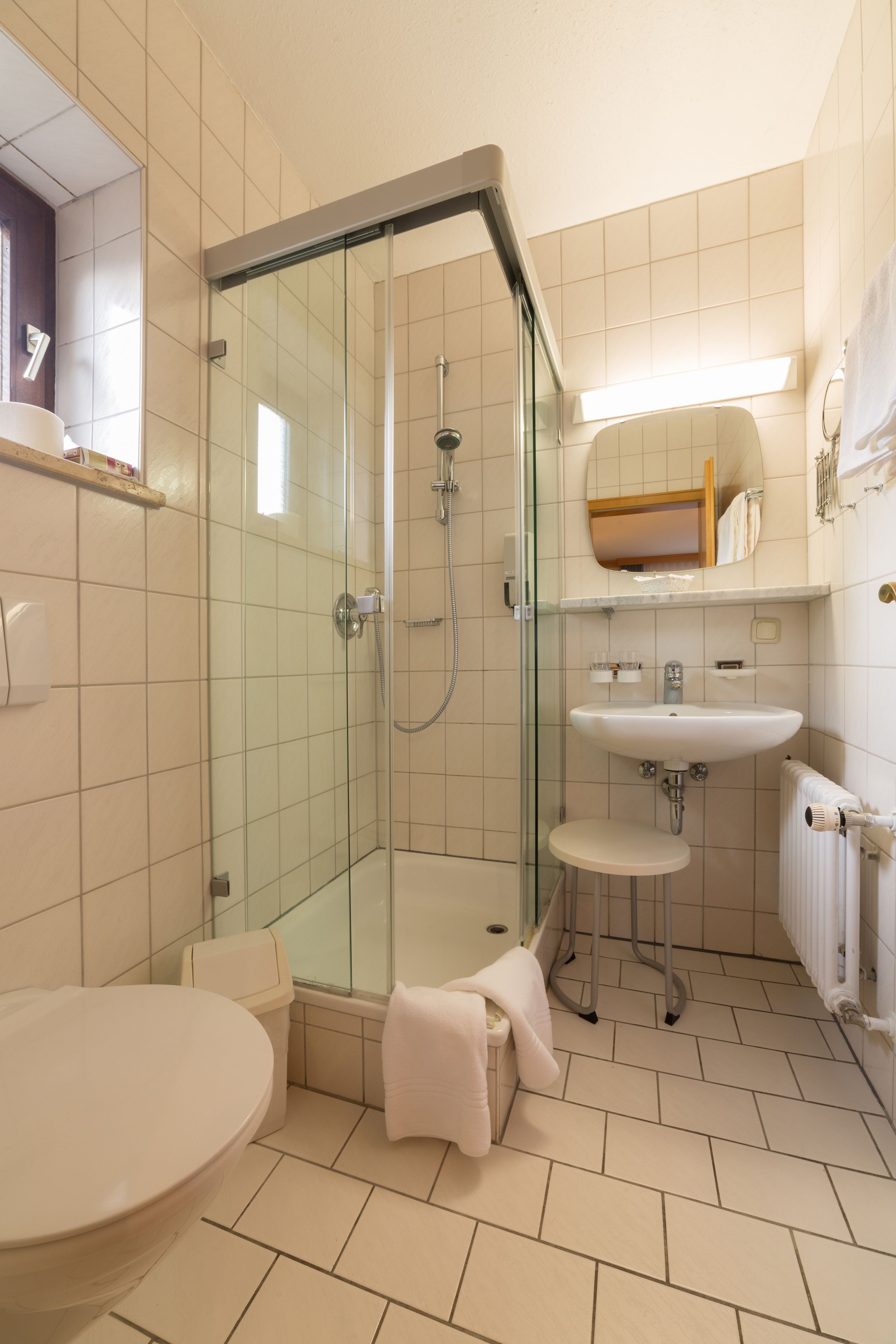 Un baño moderno con ducha de vidrio, lavamanos e inodoro.