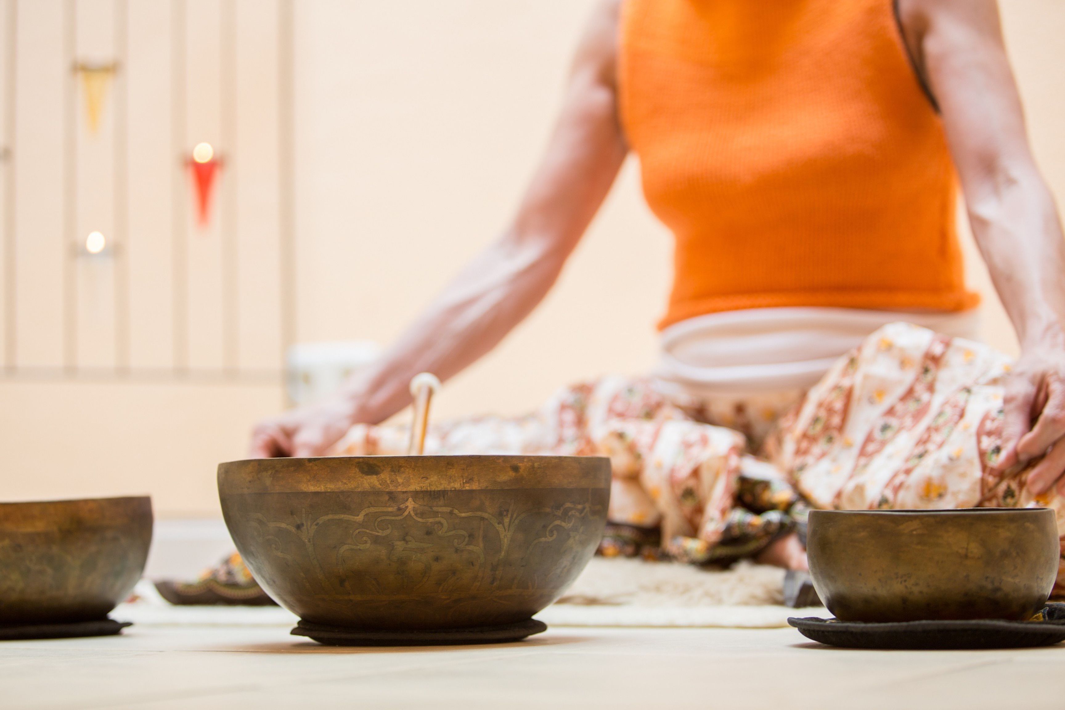 A person sitting on the floor with three bowls in front of them.