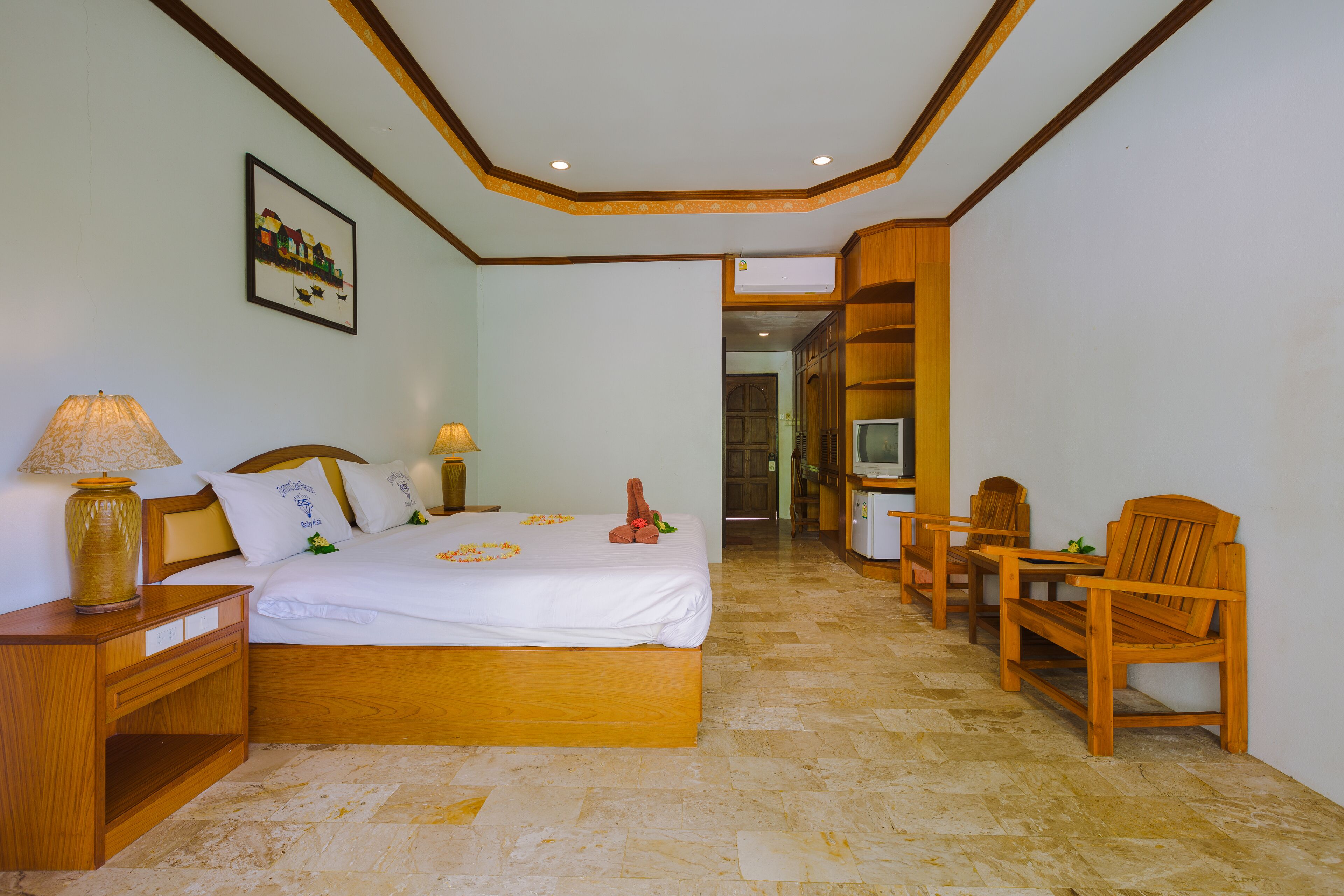 A hotel room with a wooden bed, a TV, a desk, and a chair.