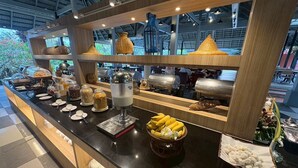 A buffet setup with various food items, a coffee machine, and decorative baskets.