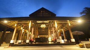 A traditional building with a covered entrance, a central chandelier, and seating areas.