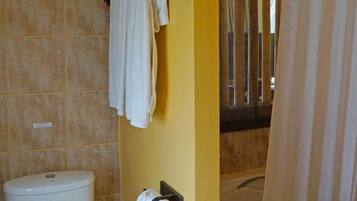 A bathroom with a toilet, a sink, a shower curtain, and a towel rack.