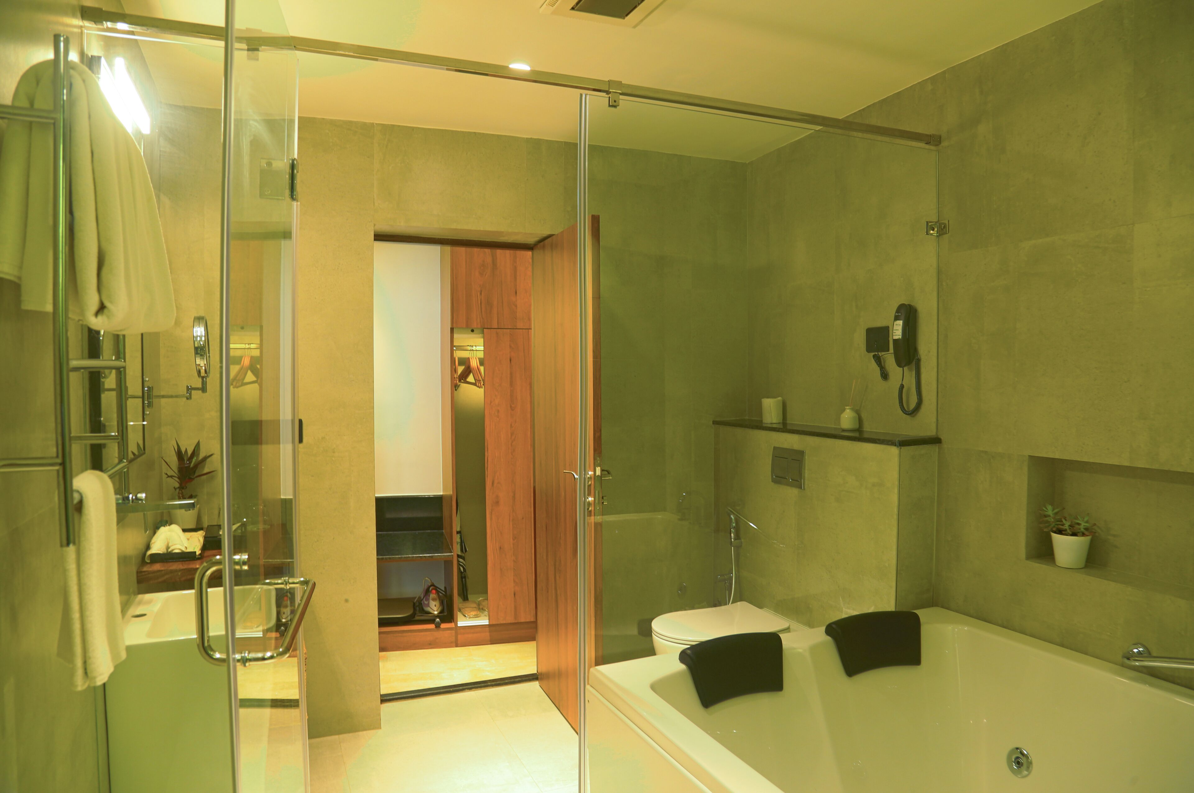 A modern bathroom with a glass-enclosed shower, a bathtub, and a toilet.