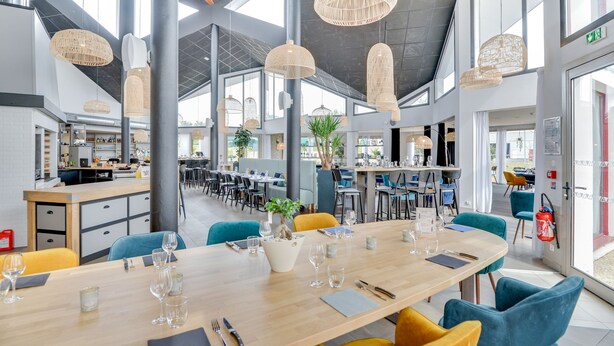 A spacious dining area with high ceilings, large windows, and modern wicker pendant lights. - Brit Hotel Au Pays de Vitre (Etrelles)