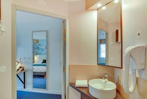 Un baño de hotel con un espejo grande, un lavabo y un teléfono.