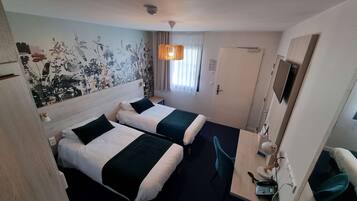A hotel room with two beds, a desk with a phone, a chair, a TV, and a decorative wall.