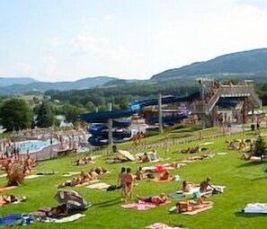 A large outdoor area with multiple pools and a grassy lawn. - Hotel Terasa (Frydek-Mistek)
