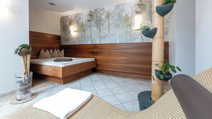 A modern bedroom with a wooden headboard, a large wall mural, and a bamboo plant structure. - Hotel Untersberg (Groedig)