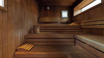 A sauna with wooden benches and a small wooden table.