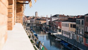 Un canal flanqueado por edificios, un puente y una torre a lo lejos.