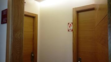 A hallway with two wooden doors, each marked with a number sign.