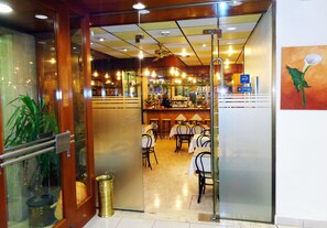 A restaurant with a bar area, tables, chairs, and a ceiling fan. - Festa Brava (Andorra la Vella)