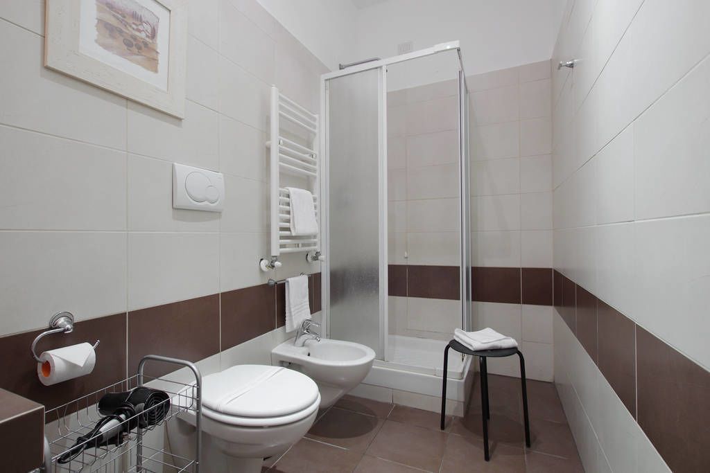 A modern bathroom with a toilet, bidet, and shower.