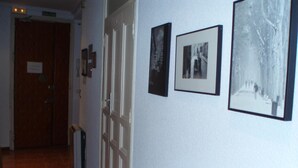 A hallway with a door labeled 'SALIDA' and three framed photographs on the wall. - Castilla (Madrid)