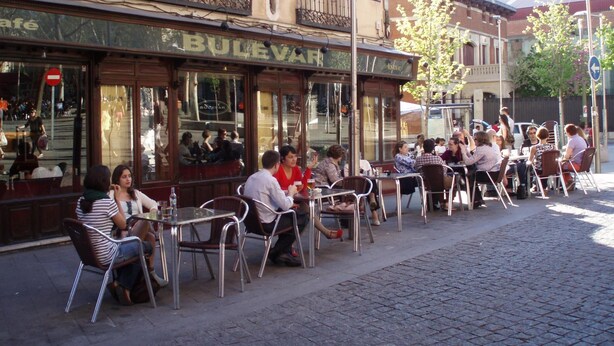 An outdoor cafe with outdoor seating, a sign reading "Bulevar", and a cobblestone street. - Castilla (Madrid)