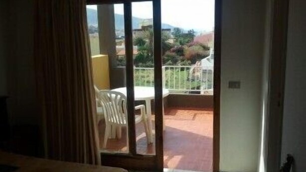 Een hotelkamer met balkon, een bed en uitzicht op het omliggende landschap.