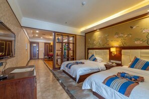 Une chambre d’hôtel avec deux lits, un bureau, une armoire et un miroir.