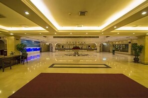 A spacious lobby with a central reception desk, a large decorative rug, and a fountain feature. - zhangjiajie Lantian Hotel (Zhangjiajie)