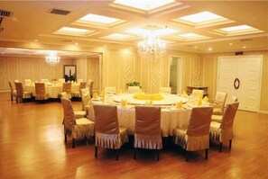 A banquet hall with round tables, chairs, chandeliers, and a large mirror. - zhangjiajie Lantian Hotel (Zhangjiajie)