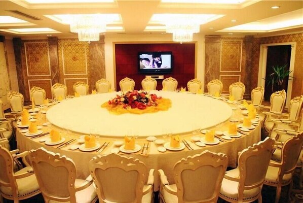 A conference room with a round table, chairs, and a television screen. - zhangjiajie Lantian Hotel (Zhangjiajie)