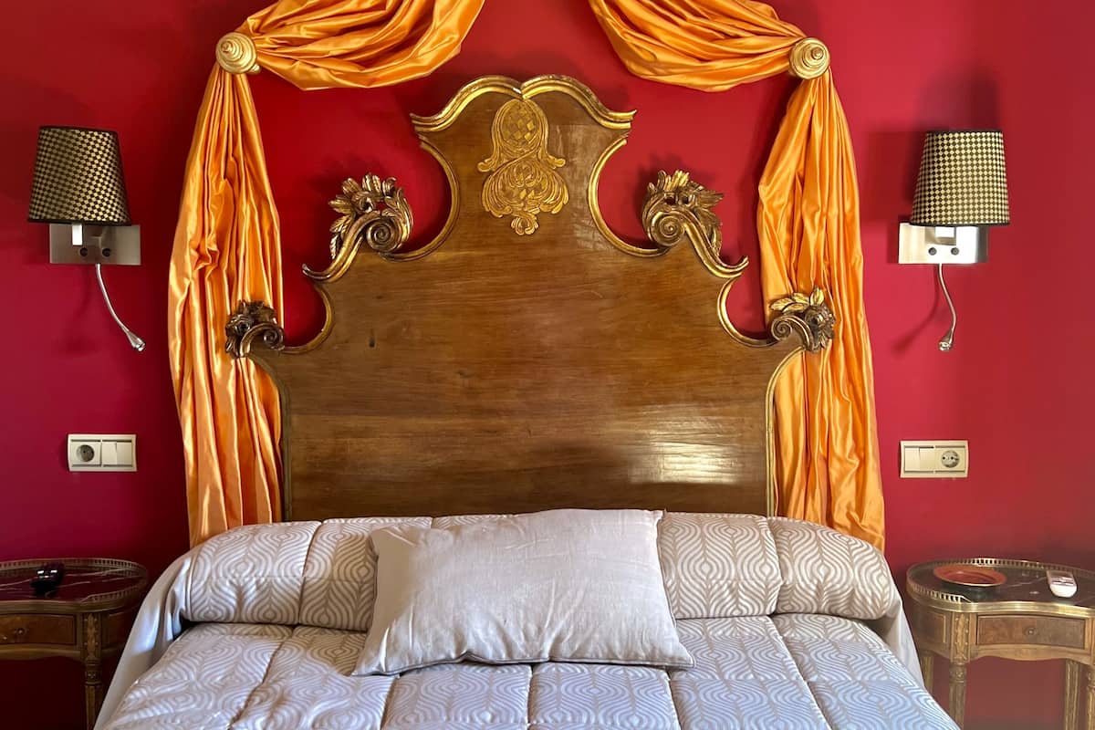 A bed with a canopy, a wooden headboard, and patterned bedding.